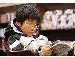 800px-Young boy reading manga