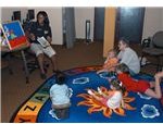 800px-US Navy 070703-N-4386D-003 T^rsquo,onna Peters, resource center library technician on board Naval Base Kitsap-Bangor, spends time reading a book to children