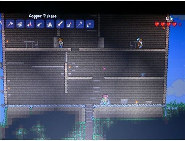 One of my characters standing inside their home in Terraria before descending underground.