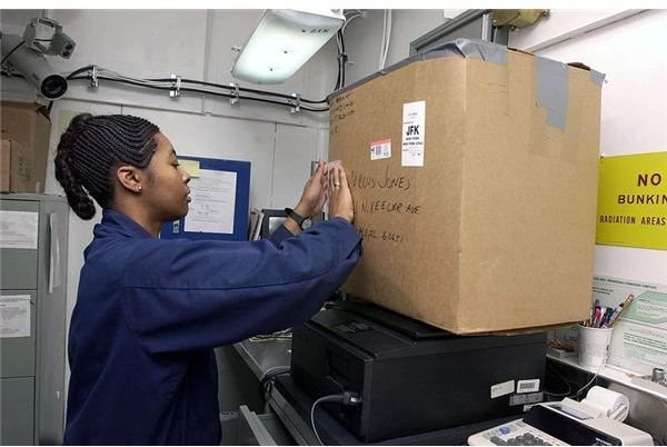 800px-US Navy 030701-N-0413R-004 Postal Clerk 3rd Class Geraldine Hood from Shreveport, La., weighs a box for a customer in the Post Office
