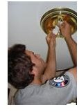 AmeriCorps volunteer installing CFL.