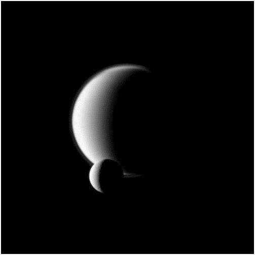 Dione in front of Titan - Crescent - Image courtesy of NASA