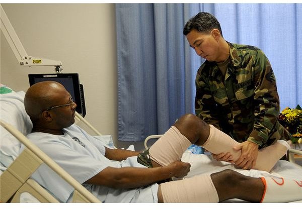 Physical therapist Lt. Cmdr. Mitchel Ideue, Officer in Charge of Inpatient Services at Landstuhl Regional Medical Center, in Landstuhl, Germany, gives Army Sgt. Charlie McCall a physical therapy trea