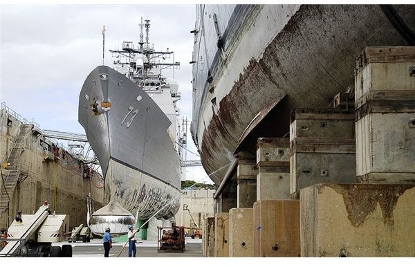 Combined Trades Supervisor II Alan Smith observes as Marine Machinery Mechanic Leader Richard Ulmer sprays water onto a fin stabilizer of the guided-missile frigate USS Crommelin (FFG 37)