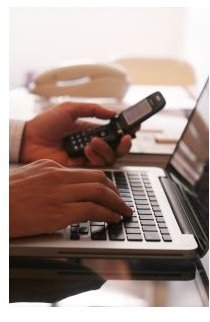 Businessman using his laptop with his cellphone