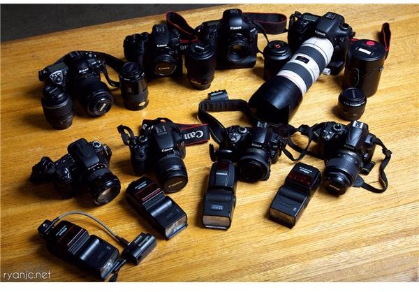 table full of cameras, lenses, and photographic gear