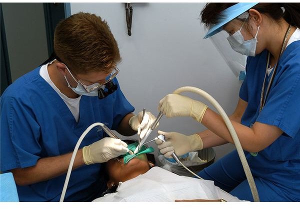 800px-US Navy 030620-N-8937A-002 Lt. William Peterson (left) of Branch Dental Clinic Sasebo, Japan drills a cavity while his dental assistant, Miho Otubo, ensures the area remains clean