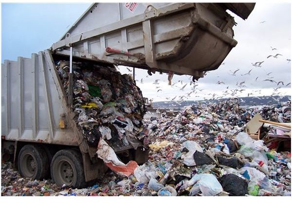 Garbage Truck Dumping Waste in a Landfill